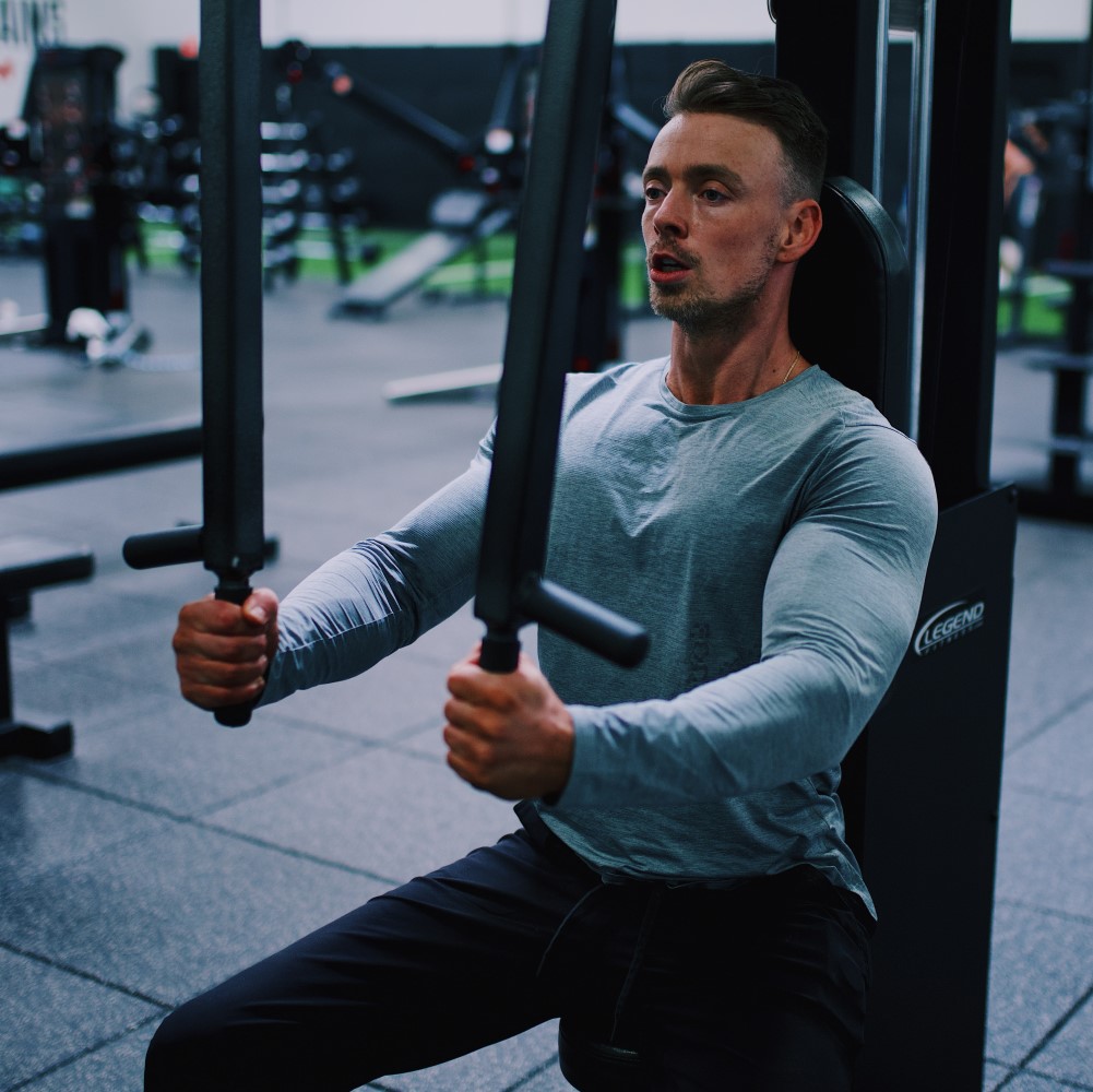 free weights and woman working out in the background using a machine