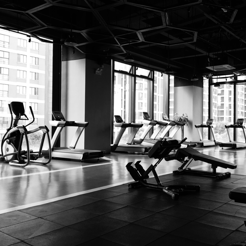 free weights and woman working out in the background using a machine