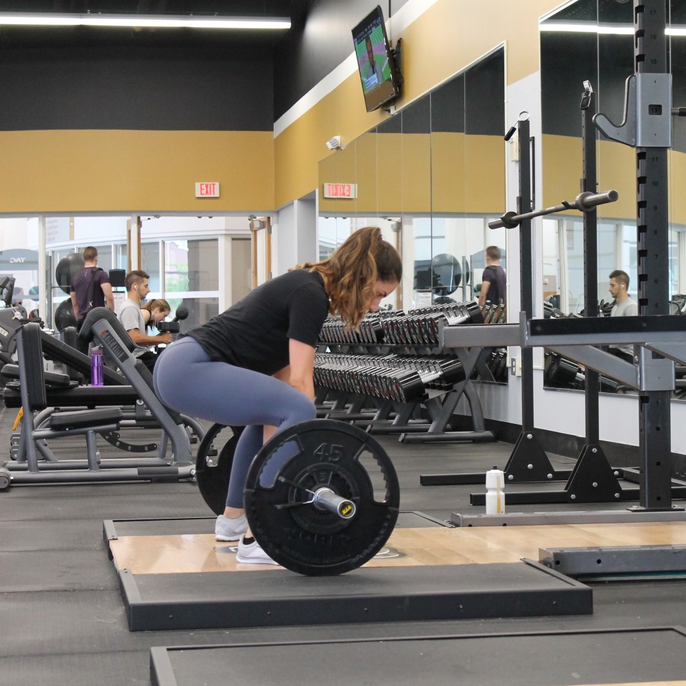 free weights and woman working out in the background using a machine