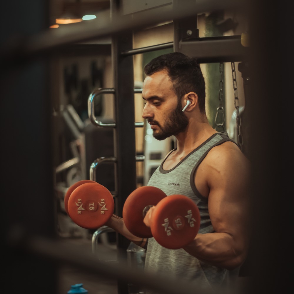 free weights and woman working out in the background using a machine