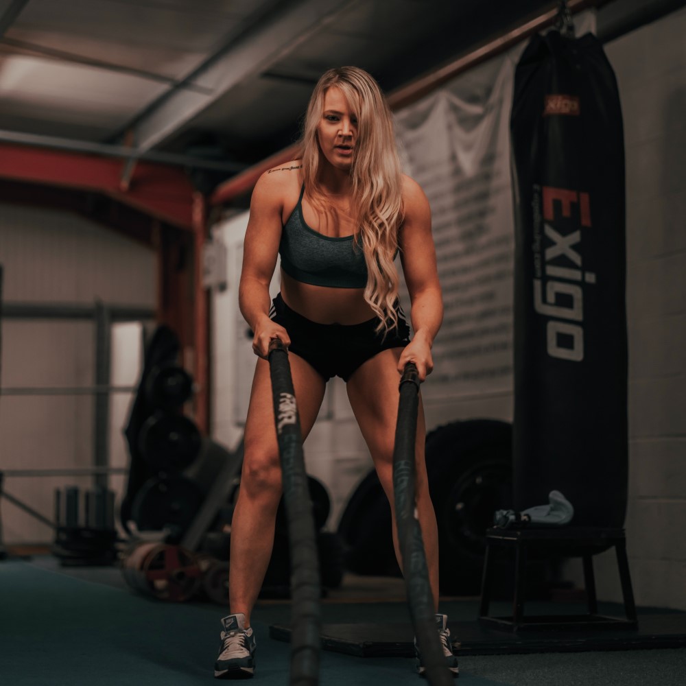 free weights and woman working out in the background using a machine